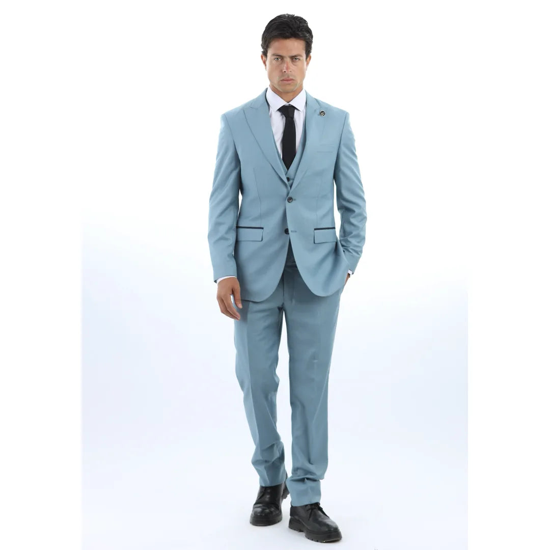 Man klädd i ljusblå kostym med vit skjorta och svart slips mot vit bakgrund