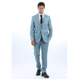 Man klädd i ljusblå kostym med vit skjorta och svart slips mot vit bakgrund