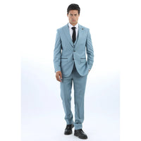 Man klädd i ljusblå kostym med vit skjorta och svart slips mot vit bakgrund